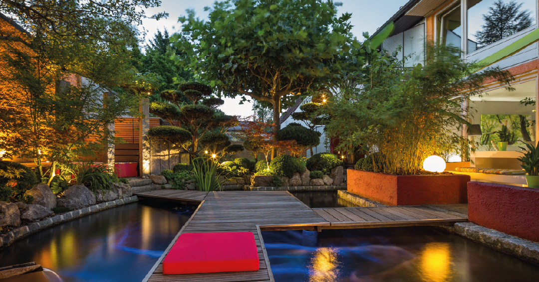 un bassin de jardin la nuit avec un éclairage extérieur