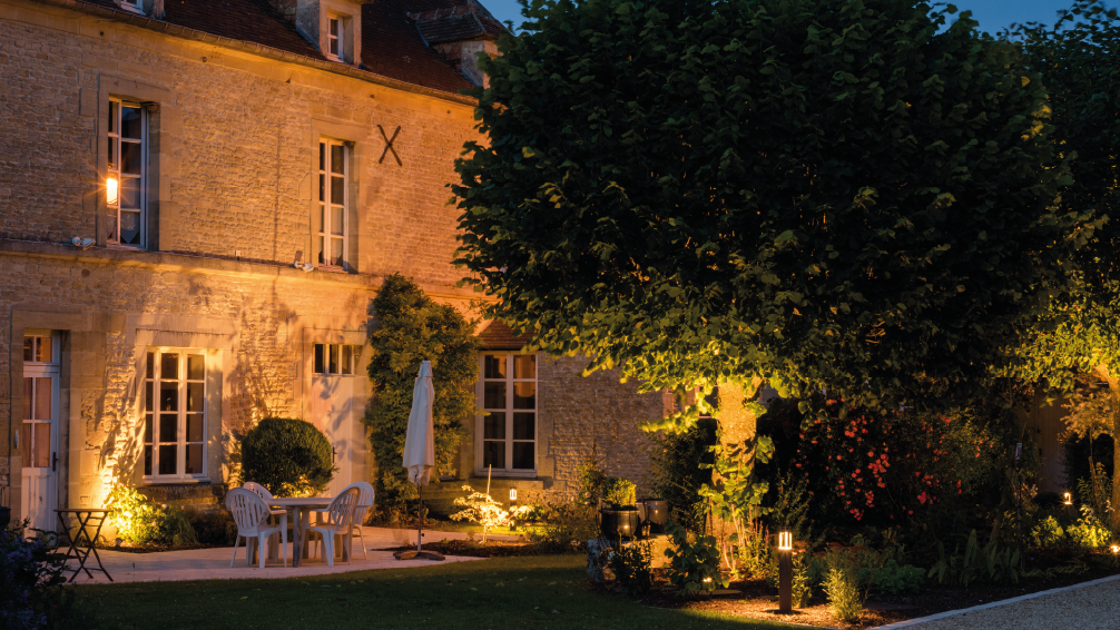 une façade de maison éclairée avec des projecteurs extérieurs