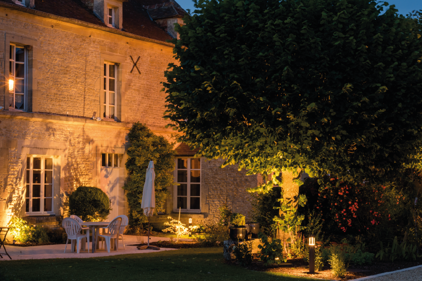 une façade de maison éclairée avec des projecteurs extérieurs