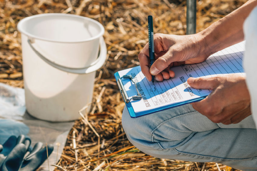 un paysagiste réalisant une analyse de sol dans un jardin