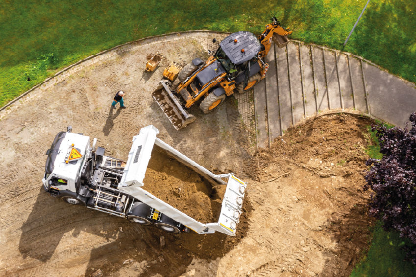 un camion benne et un bulldozer dans un jardin