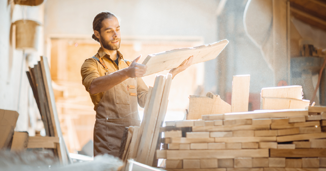 un charpentier en train de manipuler du bois écologique